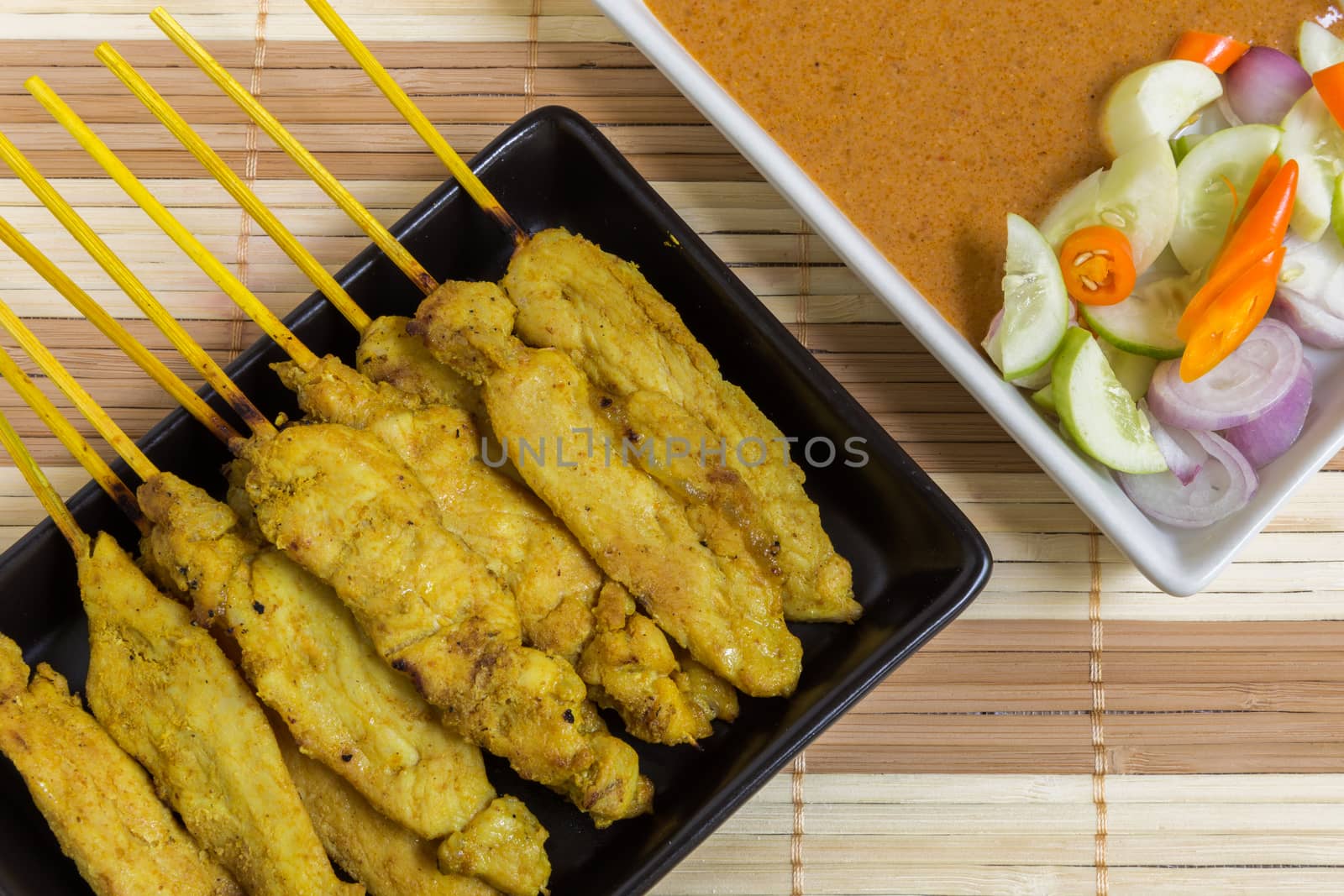 Thai grilled curry pork with peanut sauce and salad.