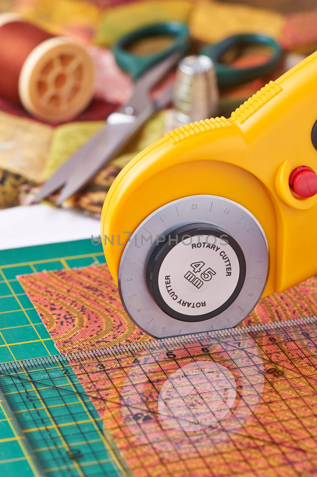 Rotary cutter cuts fabric on the a with a ruler