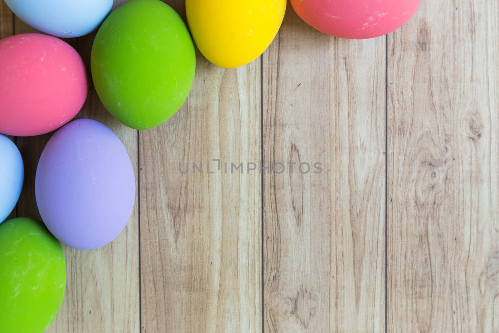 Groud of colorful eggs on wood background.