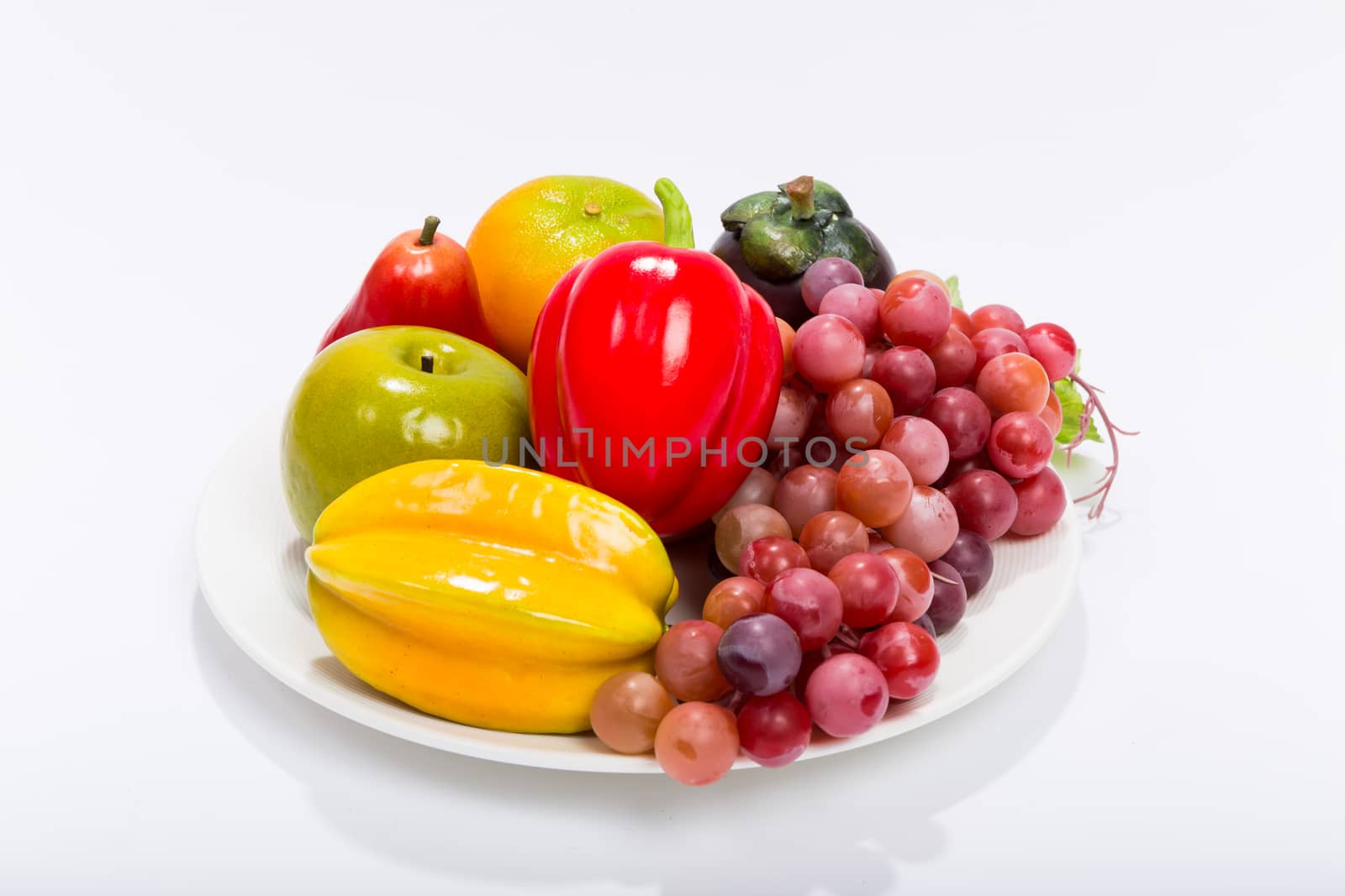 Various kinds of fruits in plate isolated on white background.