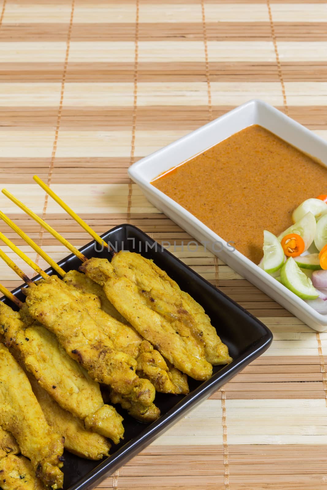 Thai grilled curry pork with peanut sauce and salad.