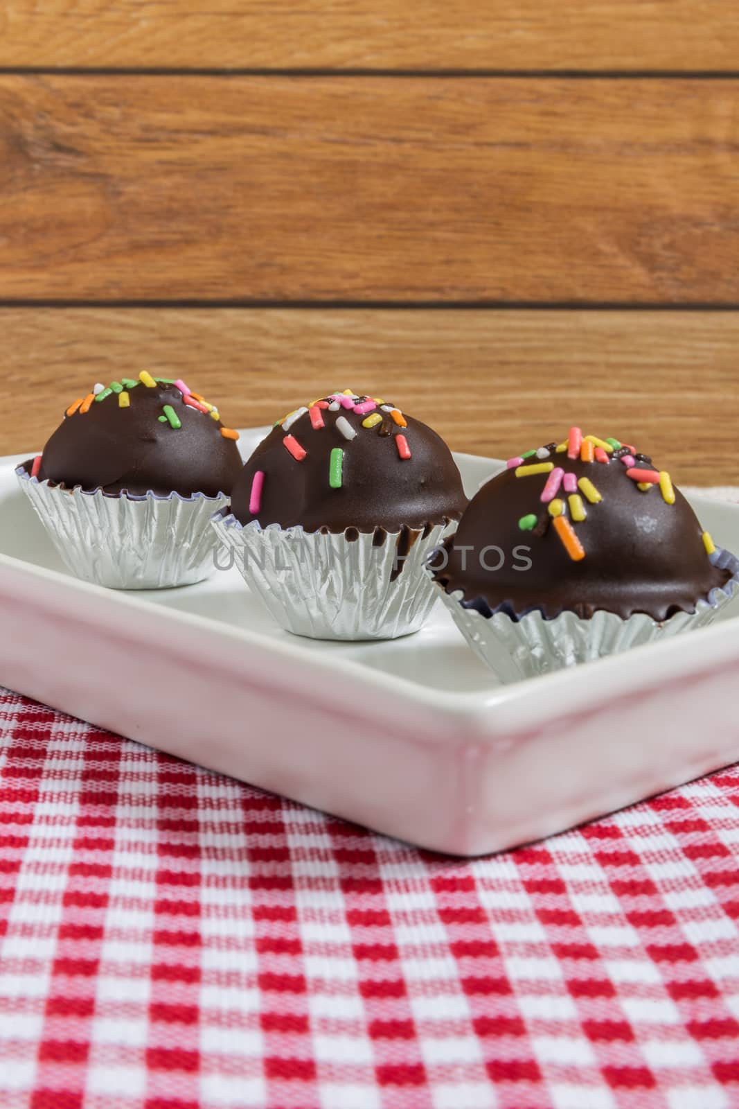 Fresh chocolate ball cakes sprinkled with colorful sugar balls.