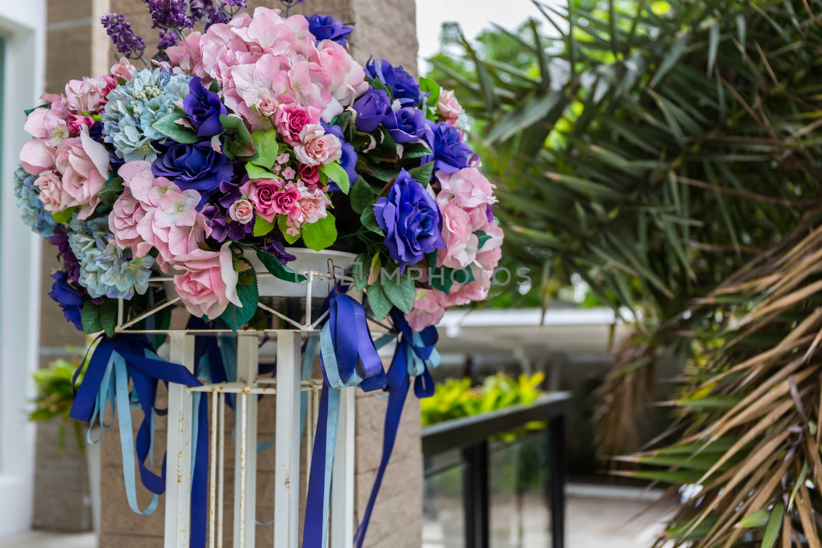 Colorful artificial flower bouquet in front of house.