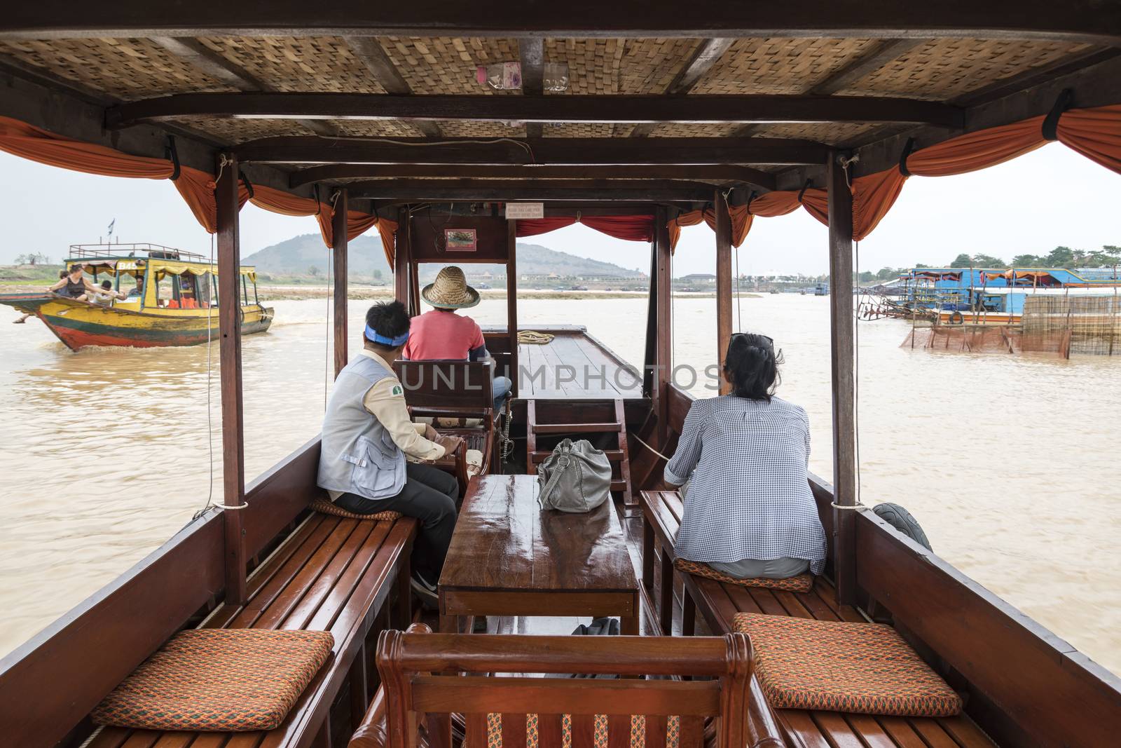 European tourist (lady) on a private cruise tour  with her guide going to visit the a village on the famous Tonle Sap Lake, Siem Reap, Cambodia, Asia