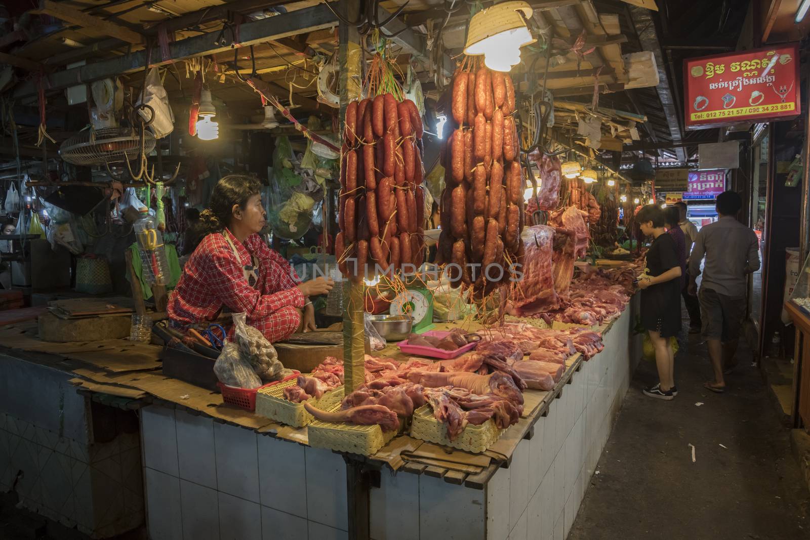 Siem Reap, Cambodia, 28 March 2018. Butcher and his meat at the Fresh Food Market