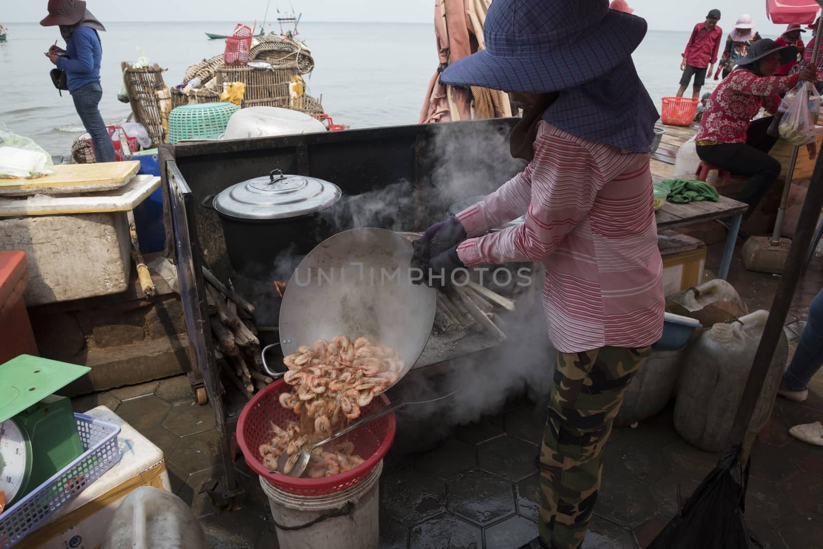Krong Kaeb, Kep Province, Cambodia, 31 March 2018. Cambodian woman cooking shrimps in a rustic kitchen at the Crab Market of Kep