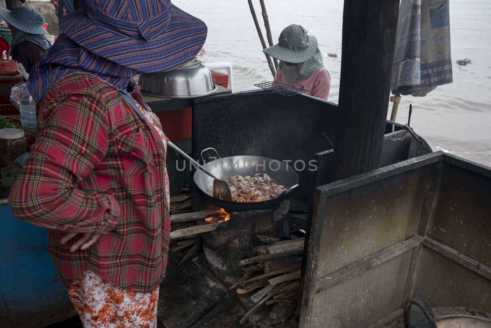 Krong Kaeb, Kep Province, Cambodia, 31 March 2018. Cambodian woman cooking octopus in a rustic kitchen at the Crab Market of Kep