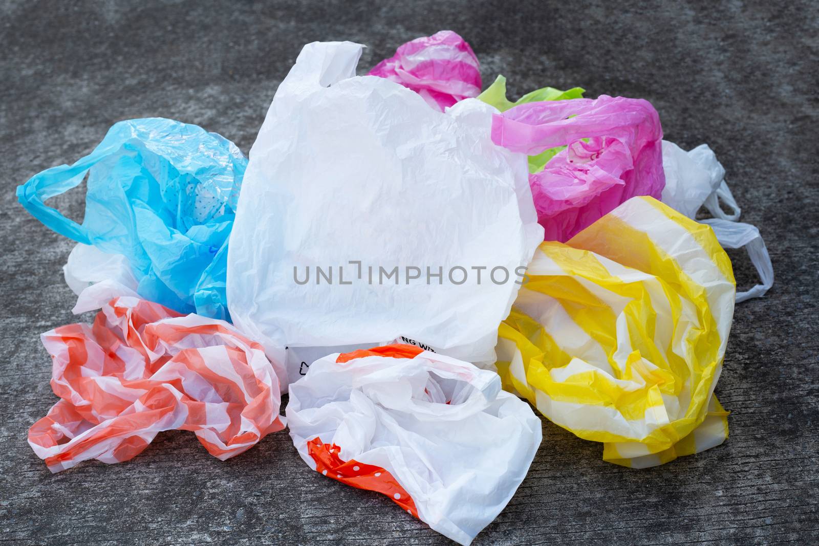 Colorful plastic bags on cement floor background