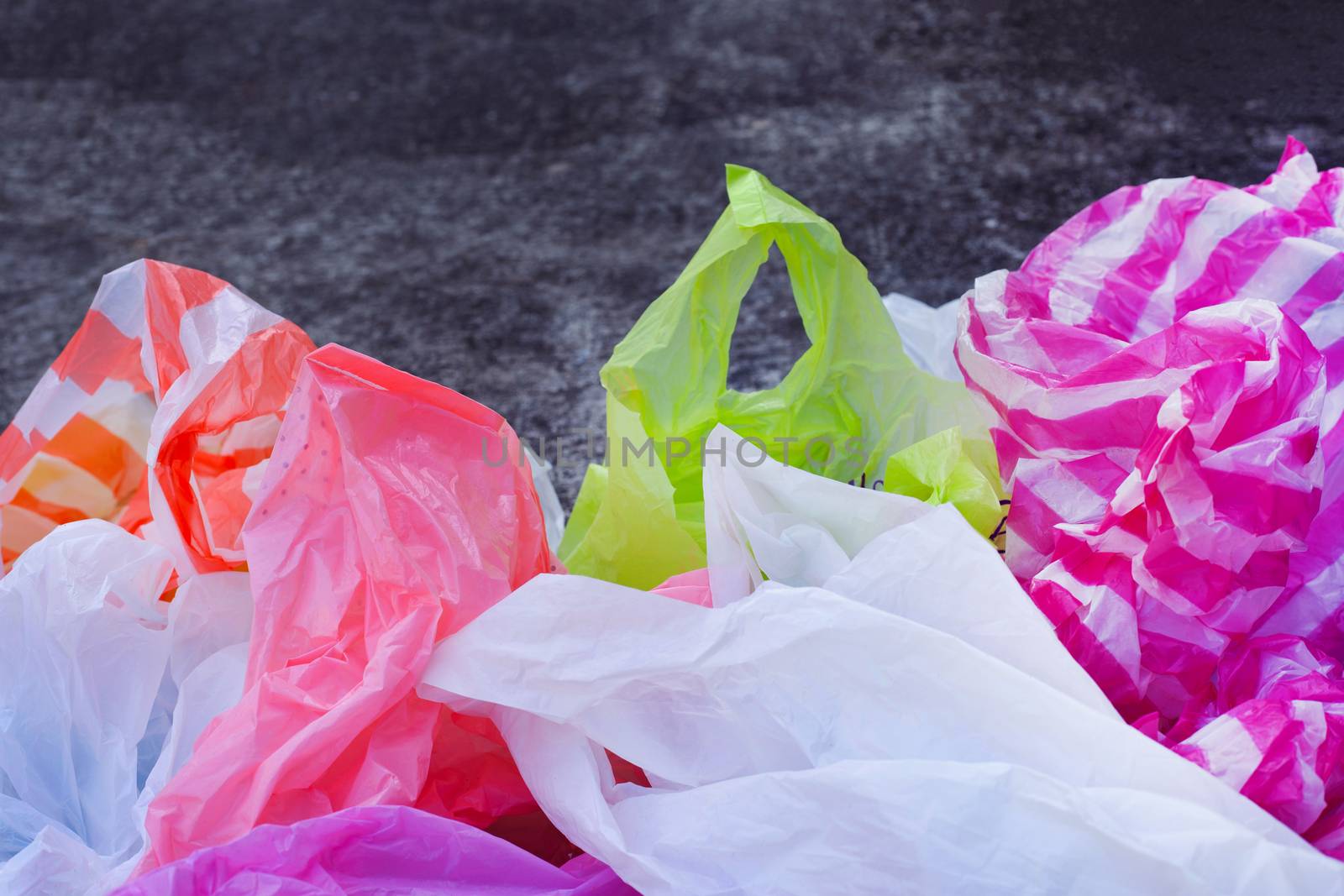Colorful plastic bags on cement floor background