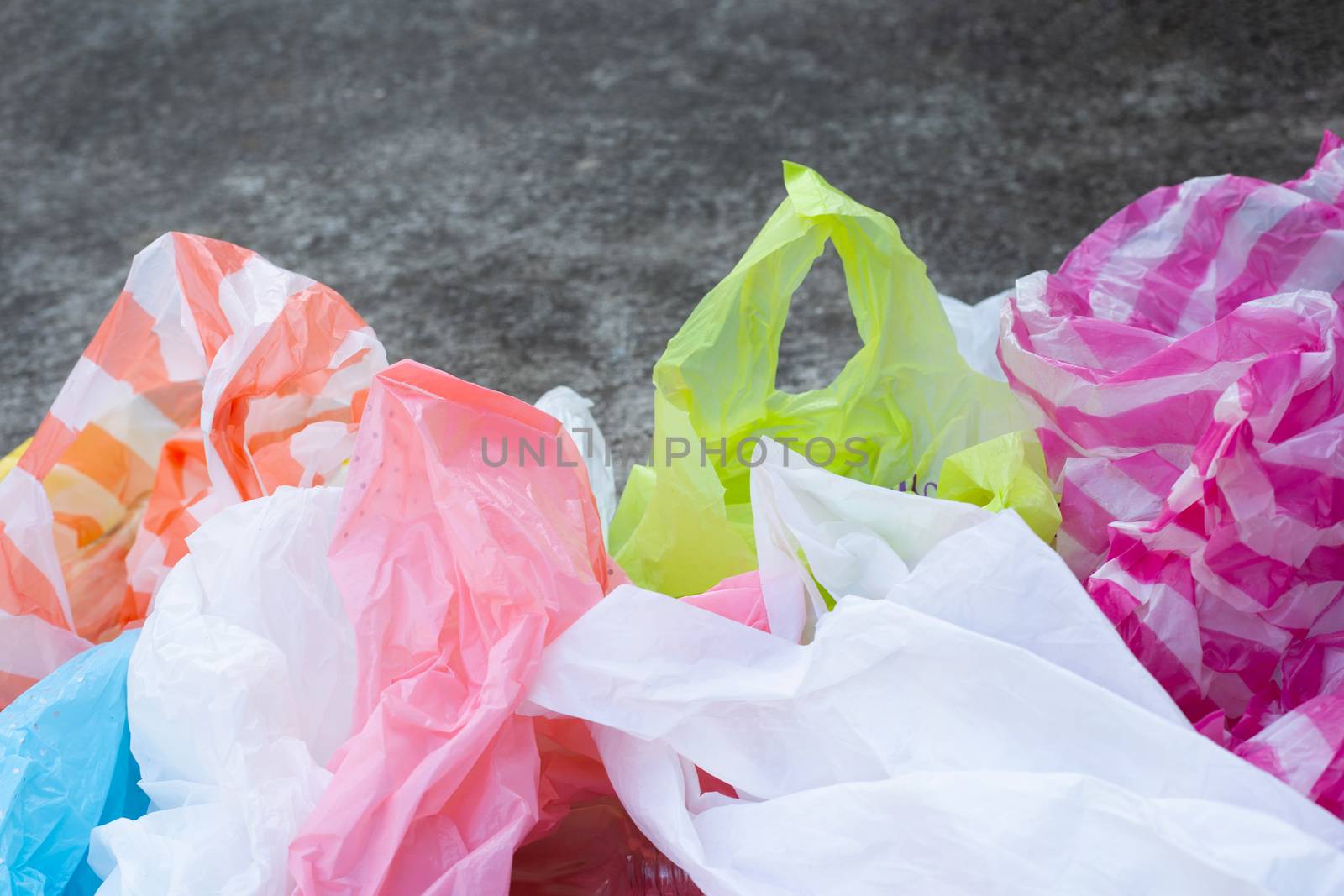 Colorful plastic bags on cement floor background