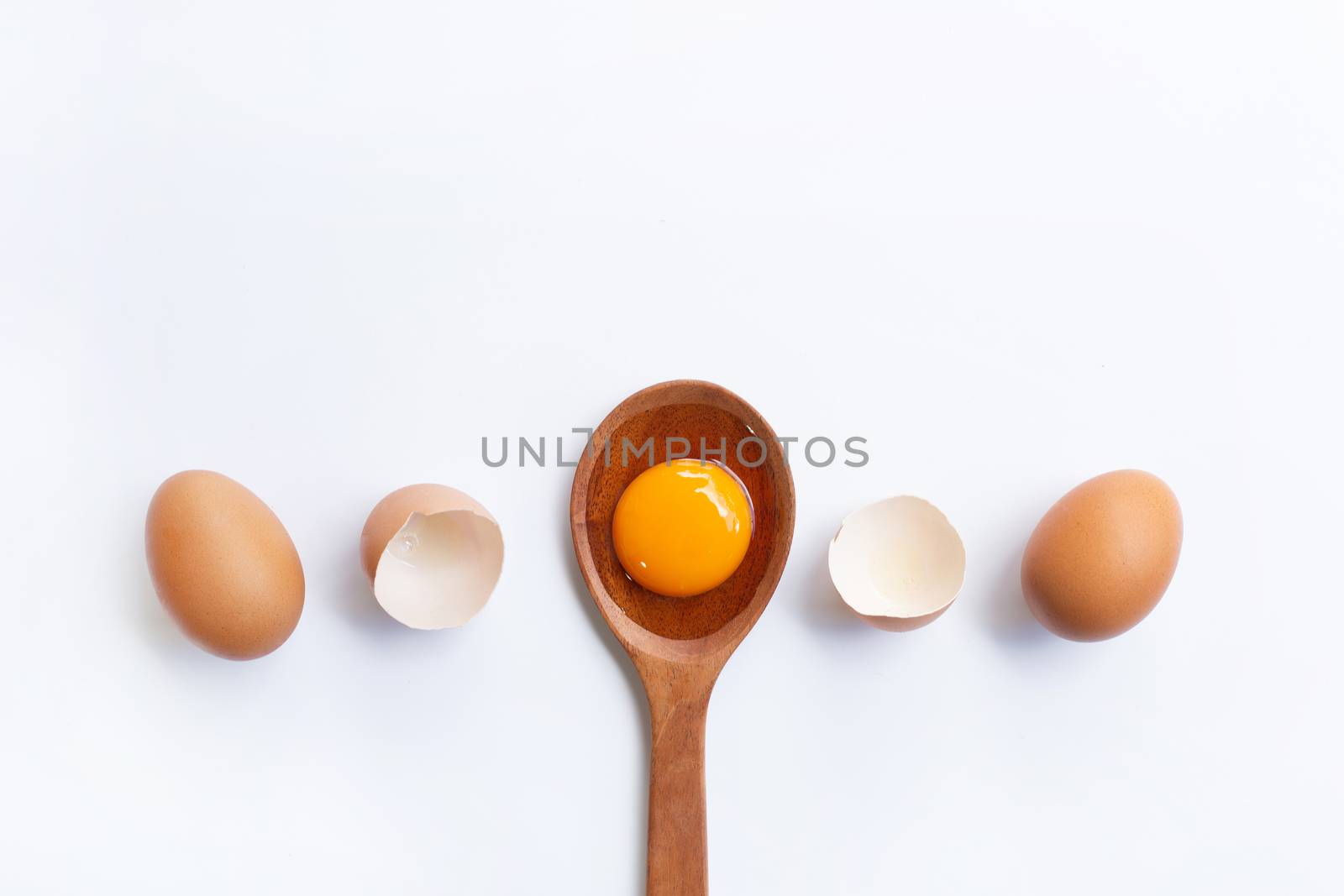 Eggs, egg yolk on wooden spoon isolated on white background.