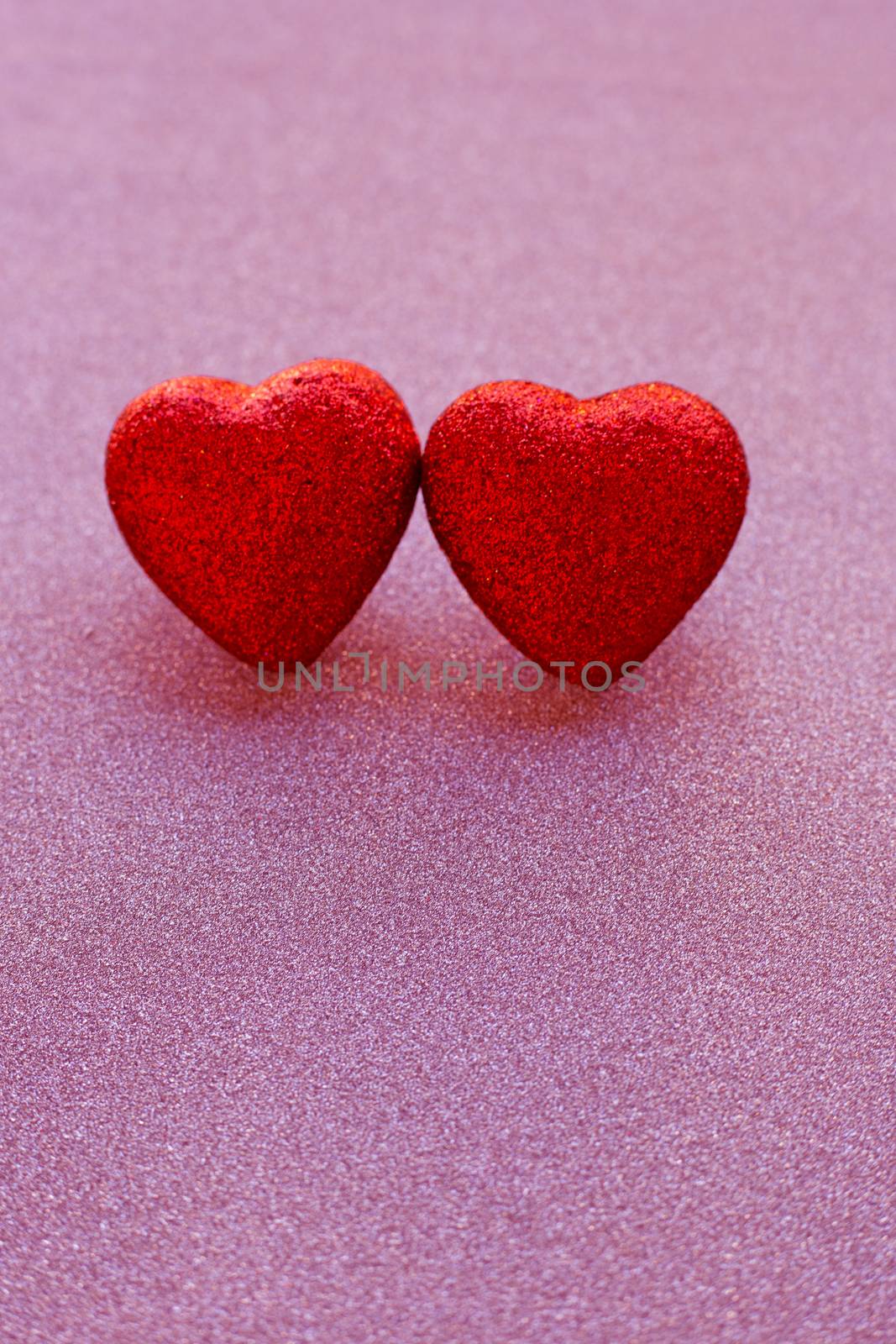 The red heart shapes on pink glitter paper background in love concept for valentines day. Copy space