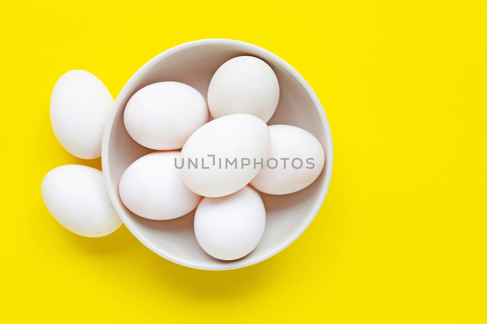 White eggs on yellow background.  Top view