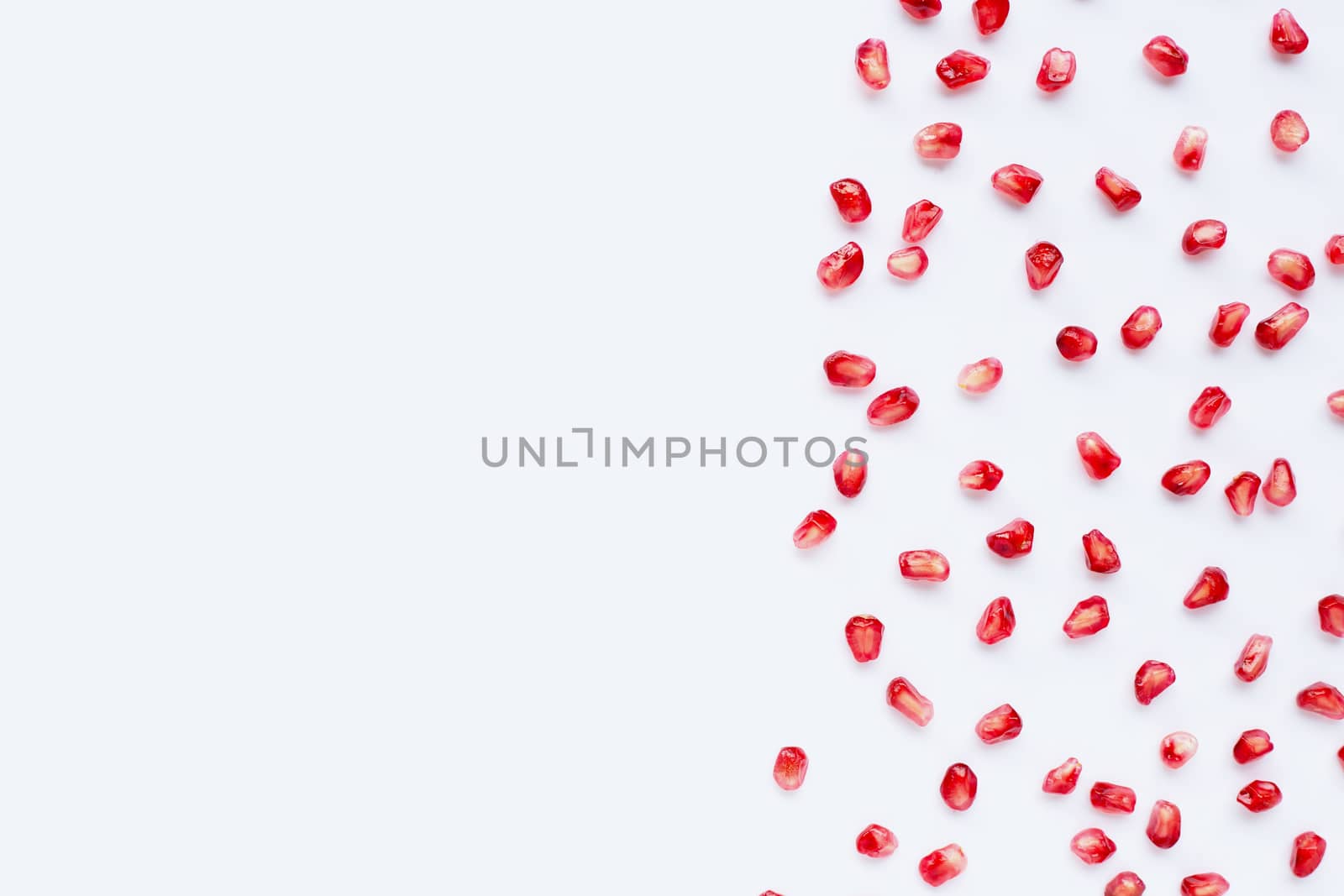 Pomegranate seeds on white background. Copy space