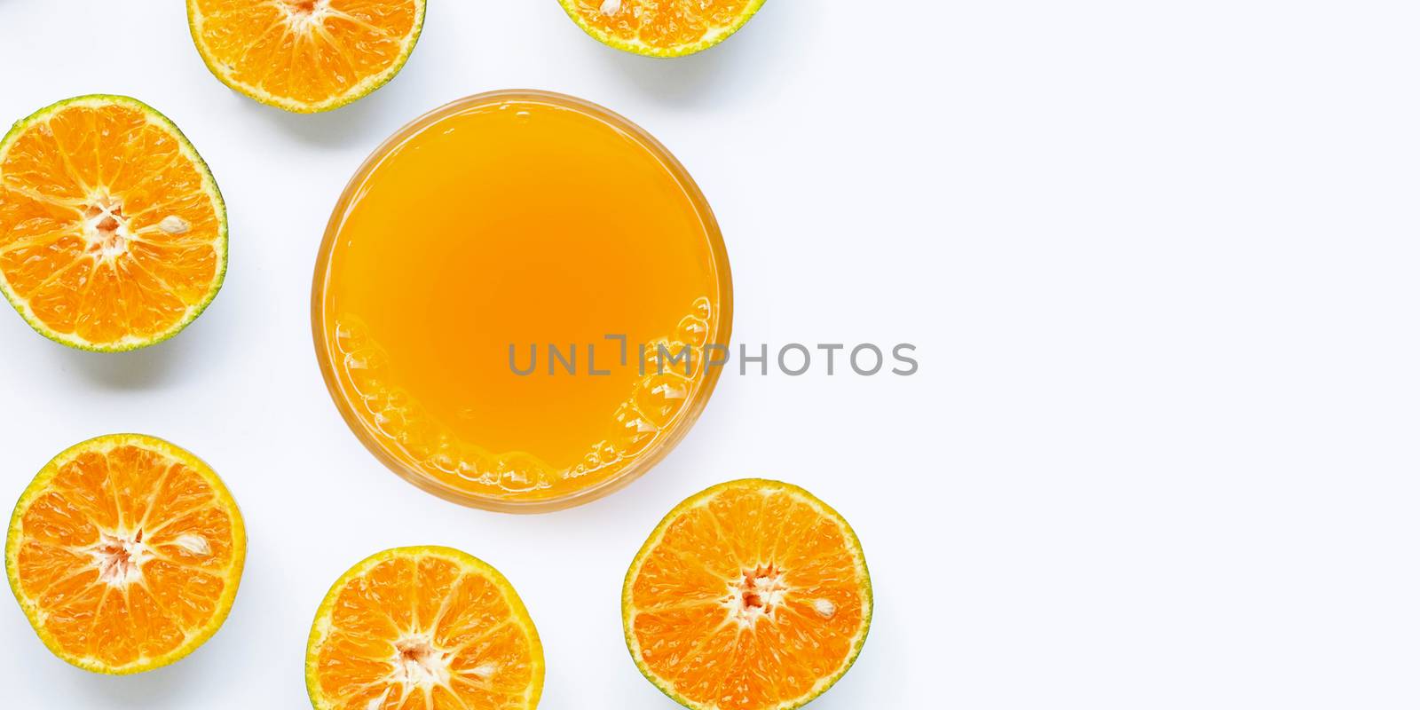 Glass of fresh orange juice on white background. Top view with copy space