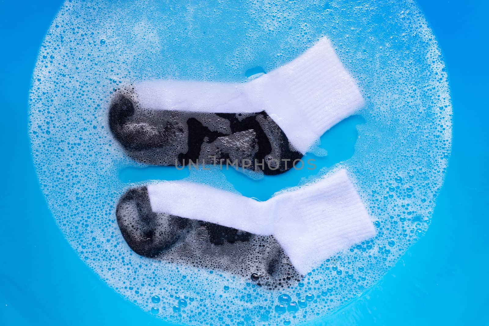 Dirty socks soaking in powder detergent water dissolution. Laundry concept