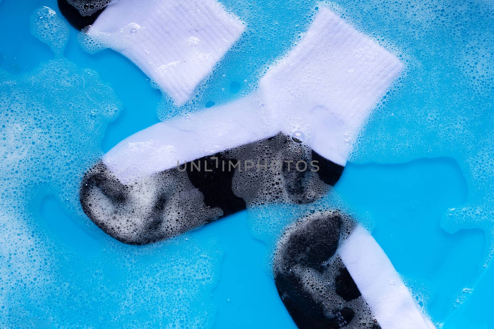 Dirty socks soaking in powder detergent water dissolution. Laundry concept