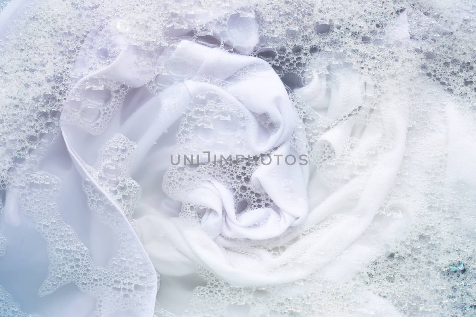 Soak white clothes in powder detergent water dissolution. Laundry concept