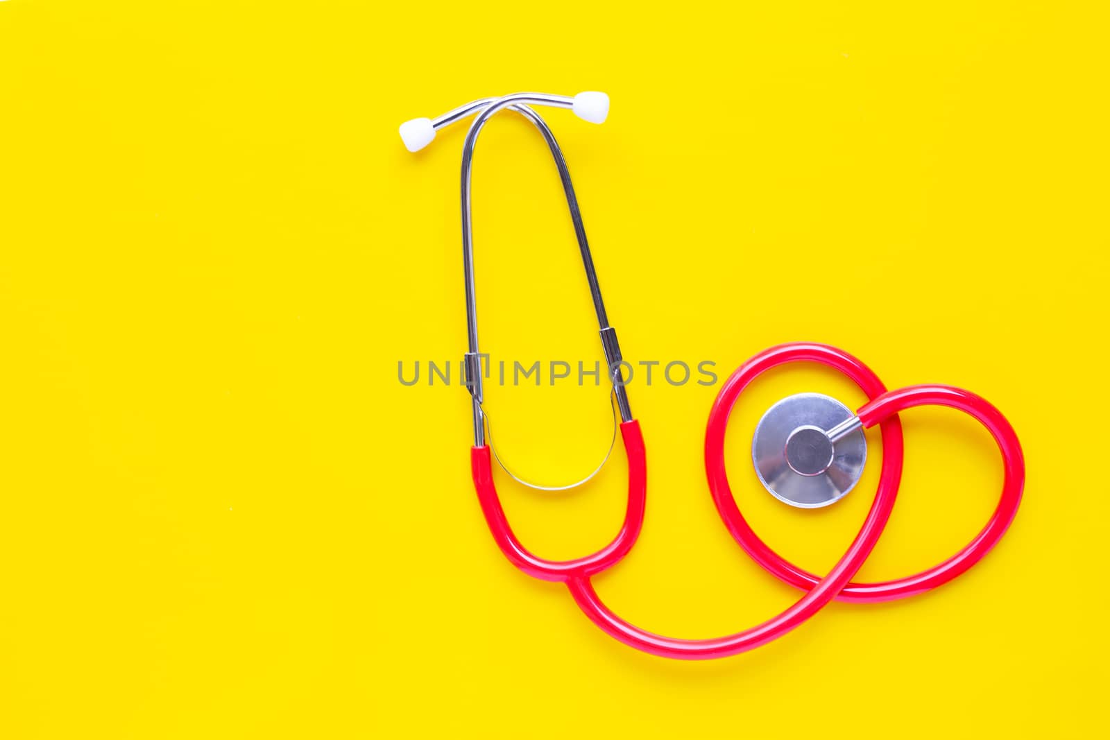 Stethoscope on yellow background with copy space