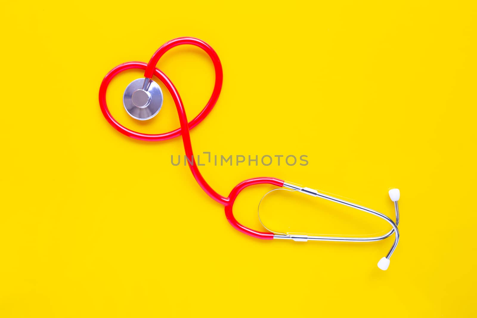 Stethoscope on yellow background with copy space