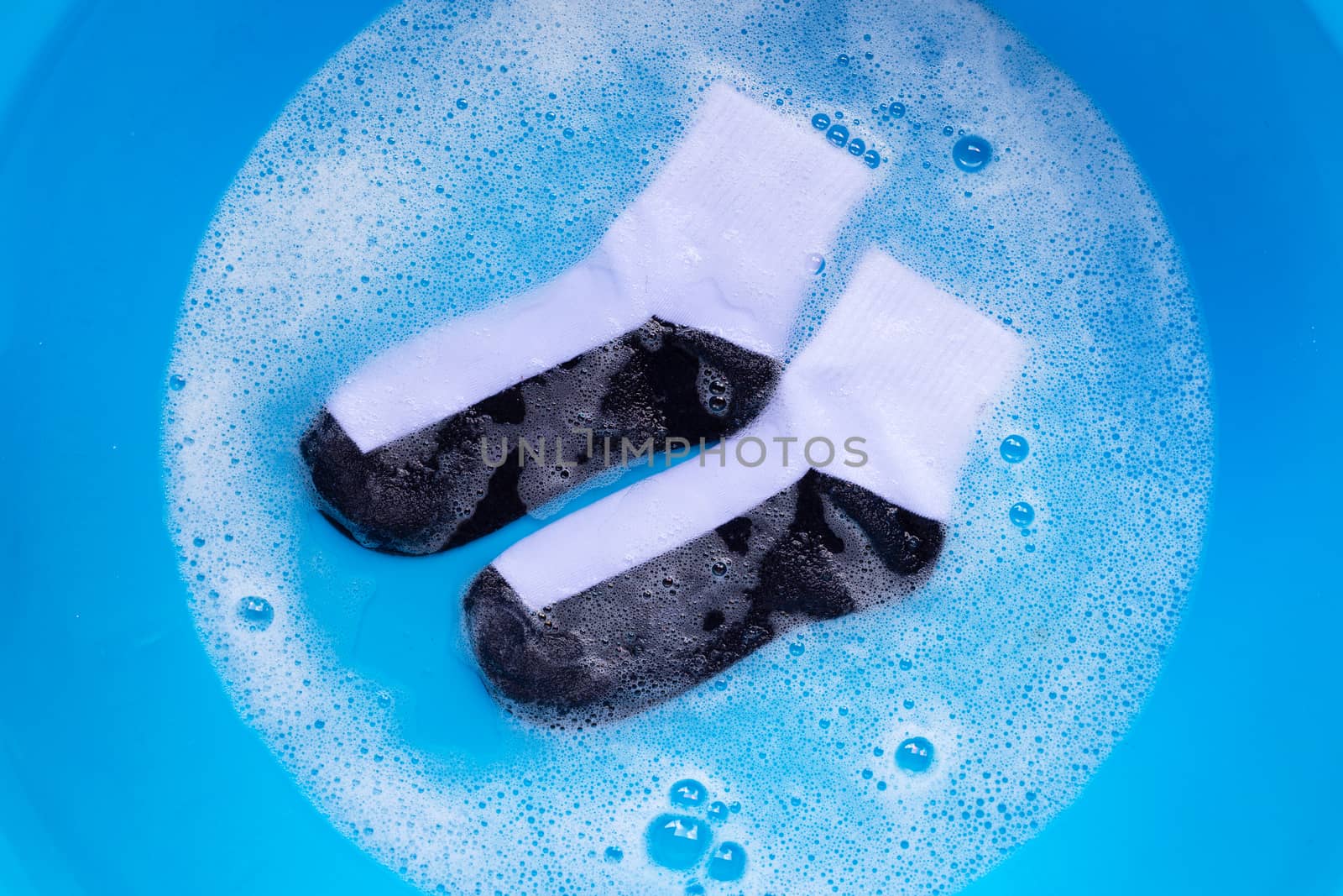 Dirty socks soaking in powder detergent water dissolution. Laundry concept