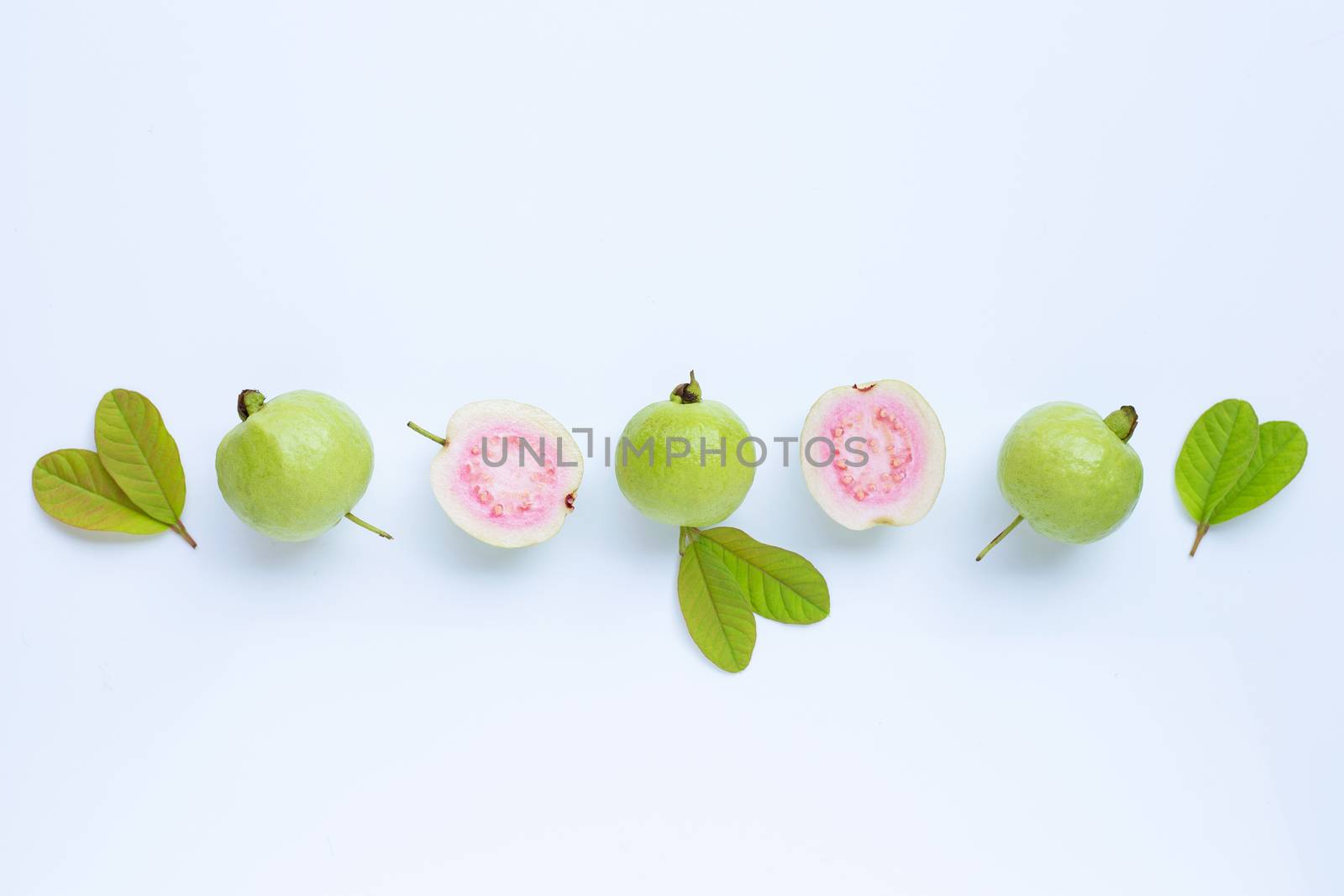 Top view of fresh ripe guava and slices with leaves.