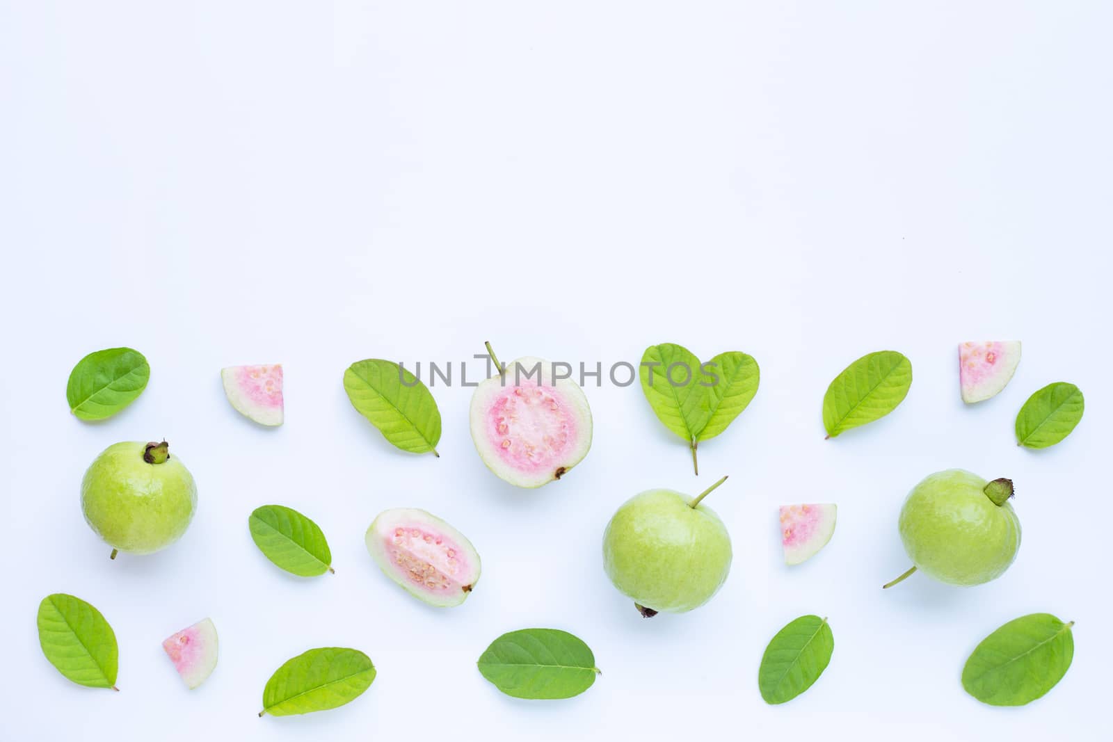 Top view of fresh ripe guava and slices with leaves on white background. Copy space