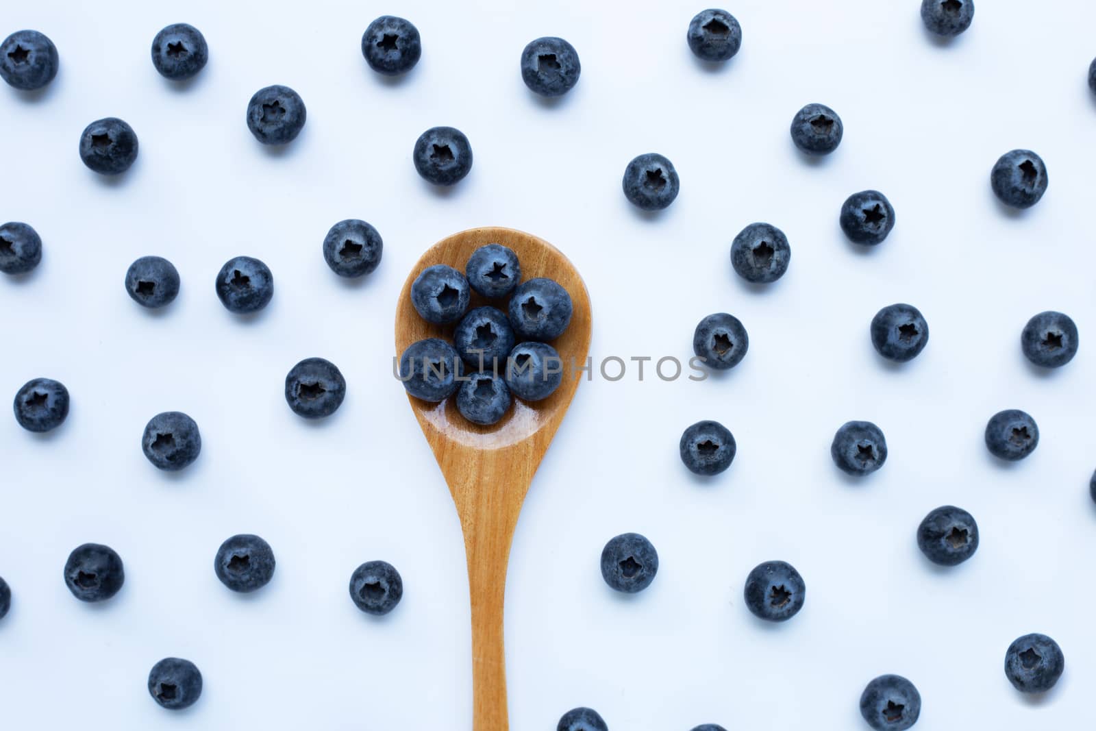 Blueberries with wooden spoon isolated on white background. Top view