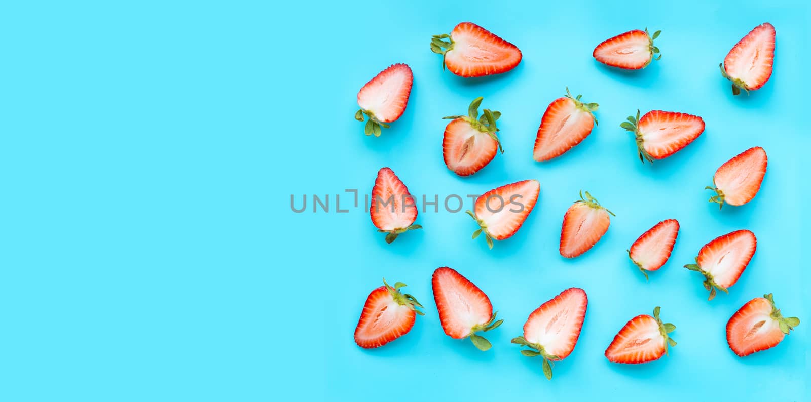 Ripe strawberries on blue background. Copy space