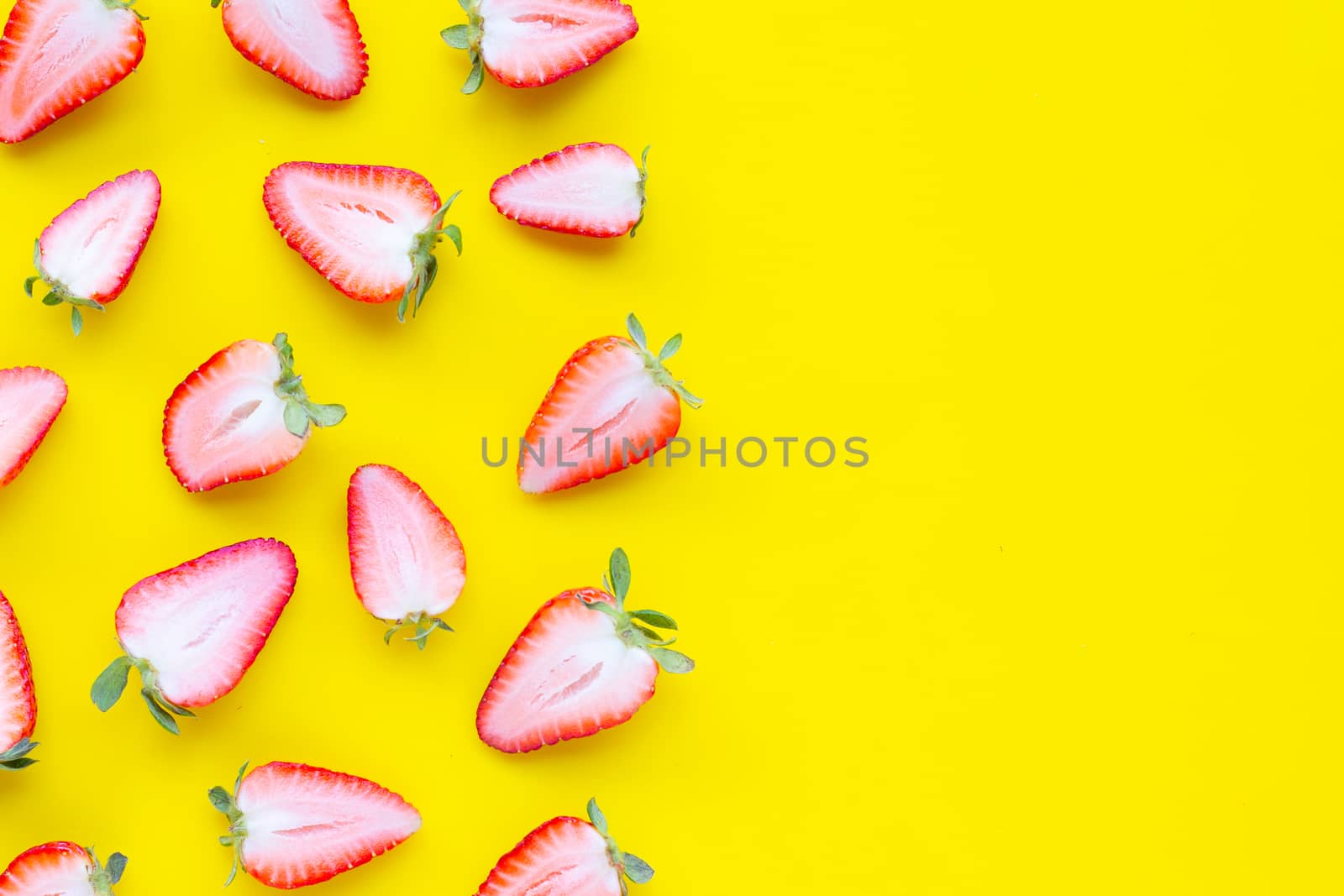 Ripe strawberries on yellow background. Copy space