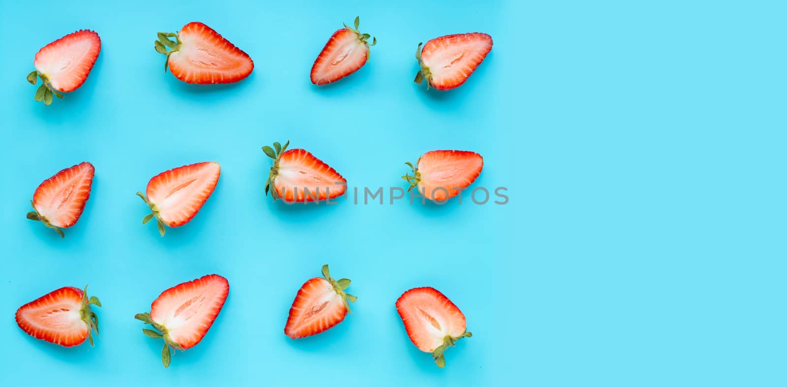 Ripe strawberries on blue background.  by Bowonpat