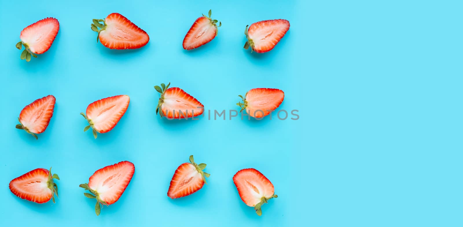 Ripe strawberries on blue background. Copy space