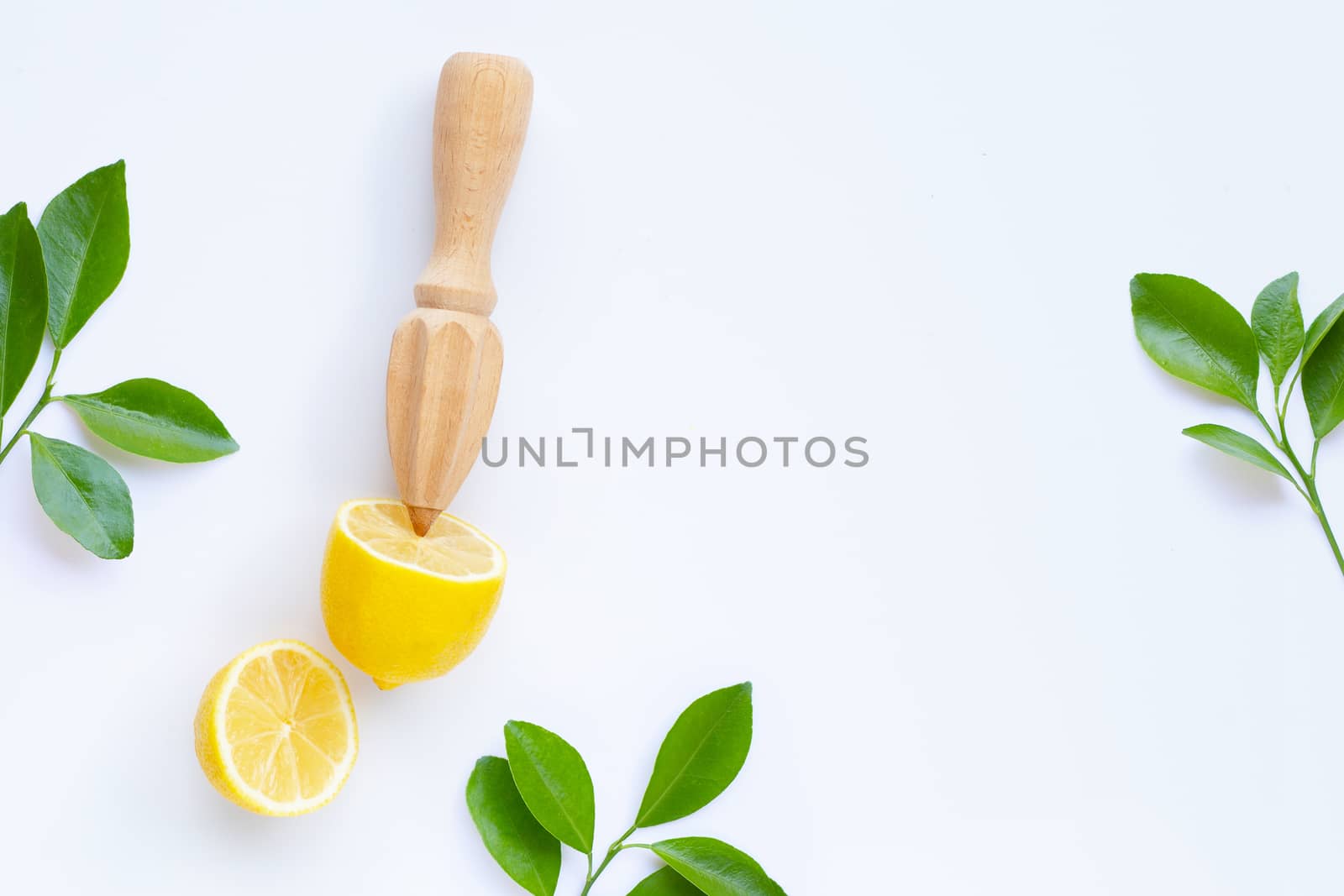 Fresh lemon and leaves with wooden juicer on white background.  Copy space