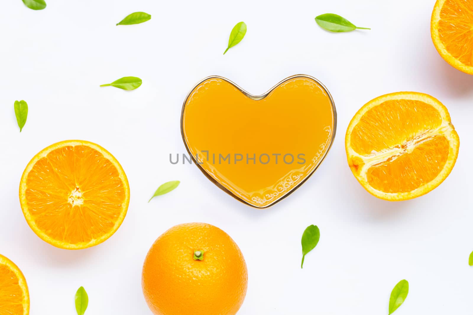 Heart shape glass of fresh orange juice with orange fruit on white background. Top view 