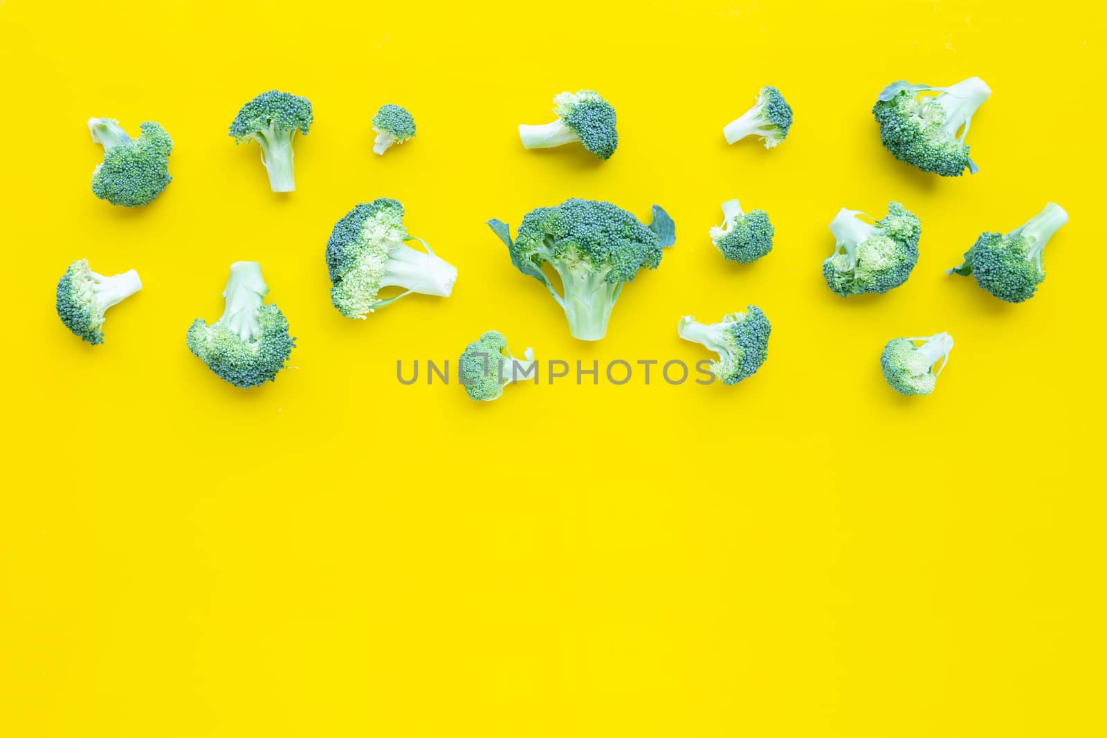 Fresh broccoli on yellow background. Copy space