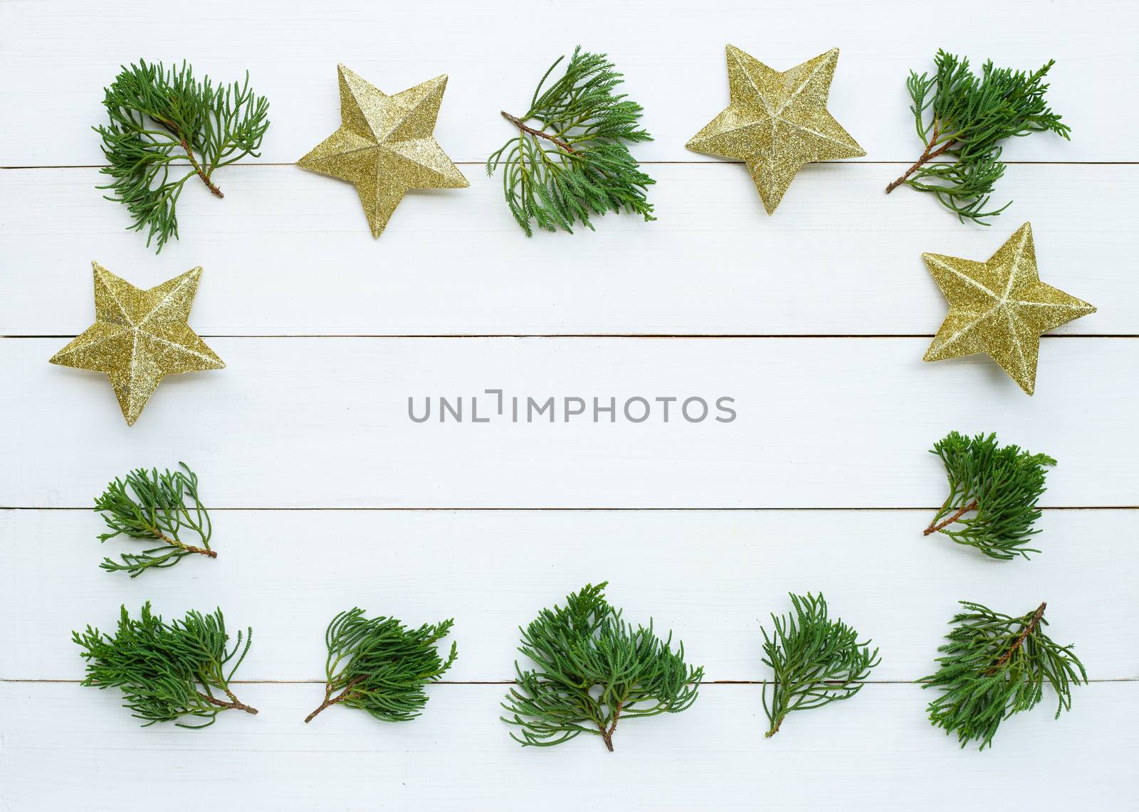 Merry Christmas and Happy Holidays, Christmas composition. golden stars, pine branches on white wooden background. Top view