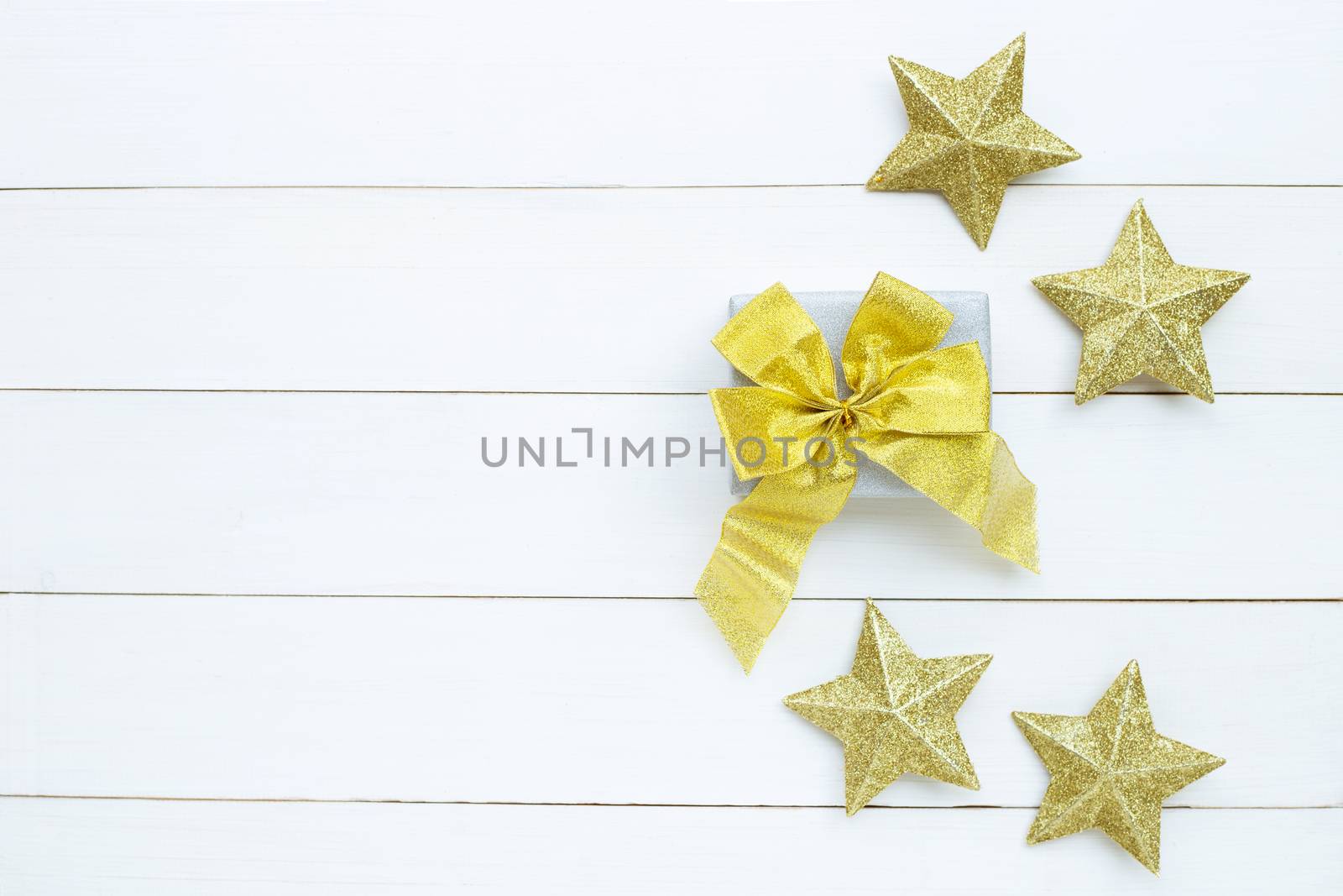Merry Christmas and Happy Holidays, Christmas composition. gift box, golden stars on white wooden background. Top view