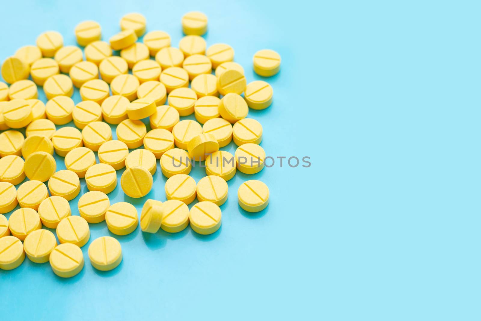 Yellow tablets of Paracetamol on blue background.  Copy space