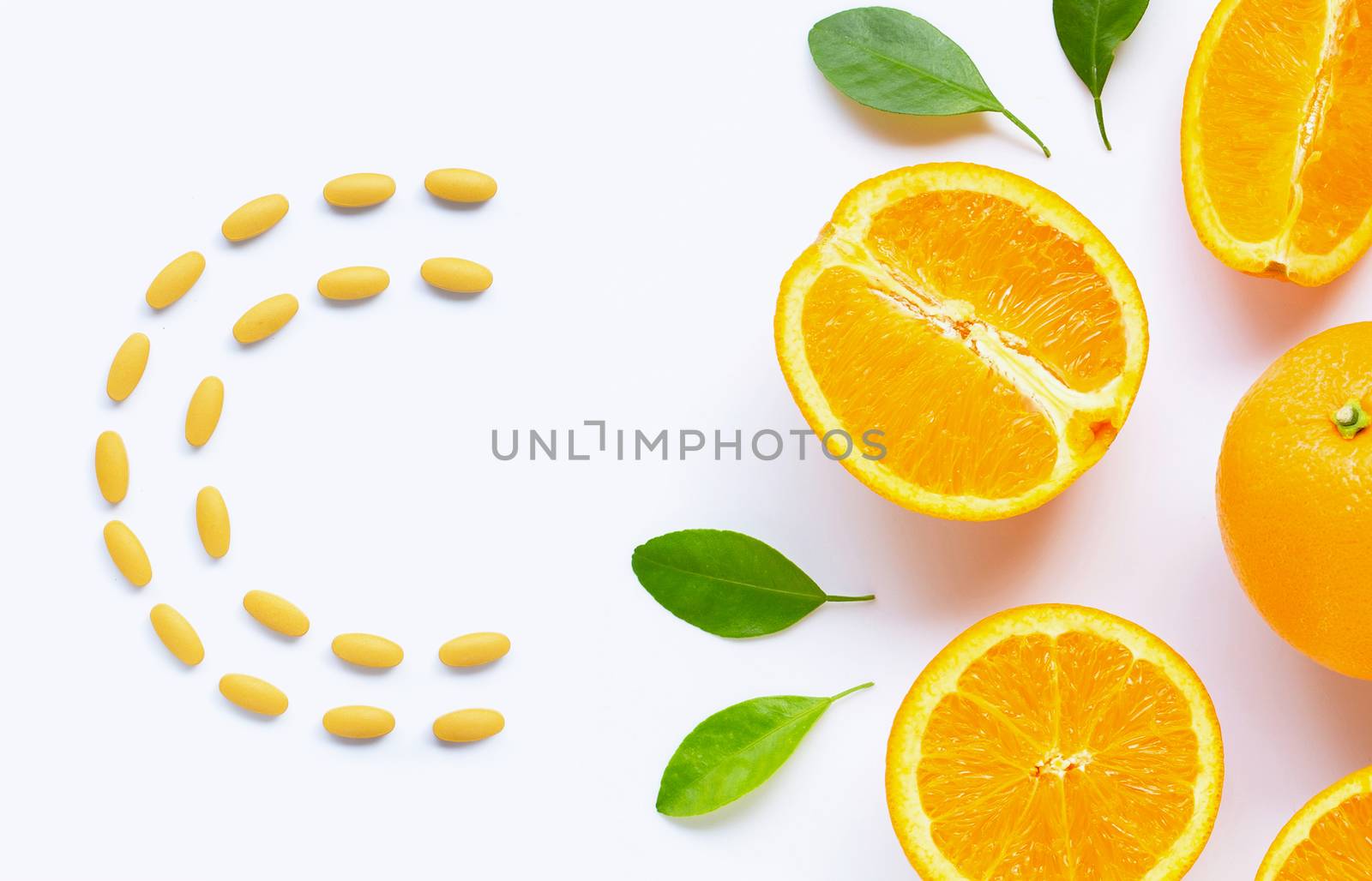 Vitamin C pills with  fresh orange citrus fruit isolated on white background.