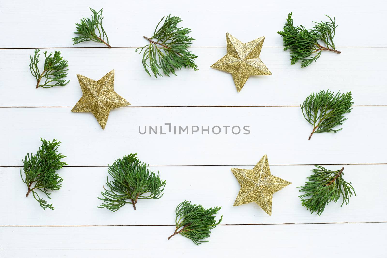 Merry Christmas and Happy Holidays, Christmas composition. golden stars, pine branches on white wooden background. Top view