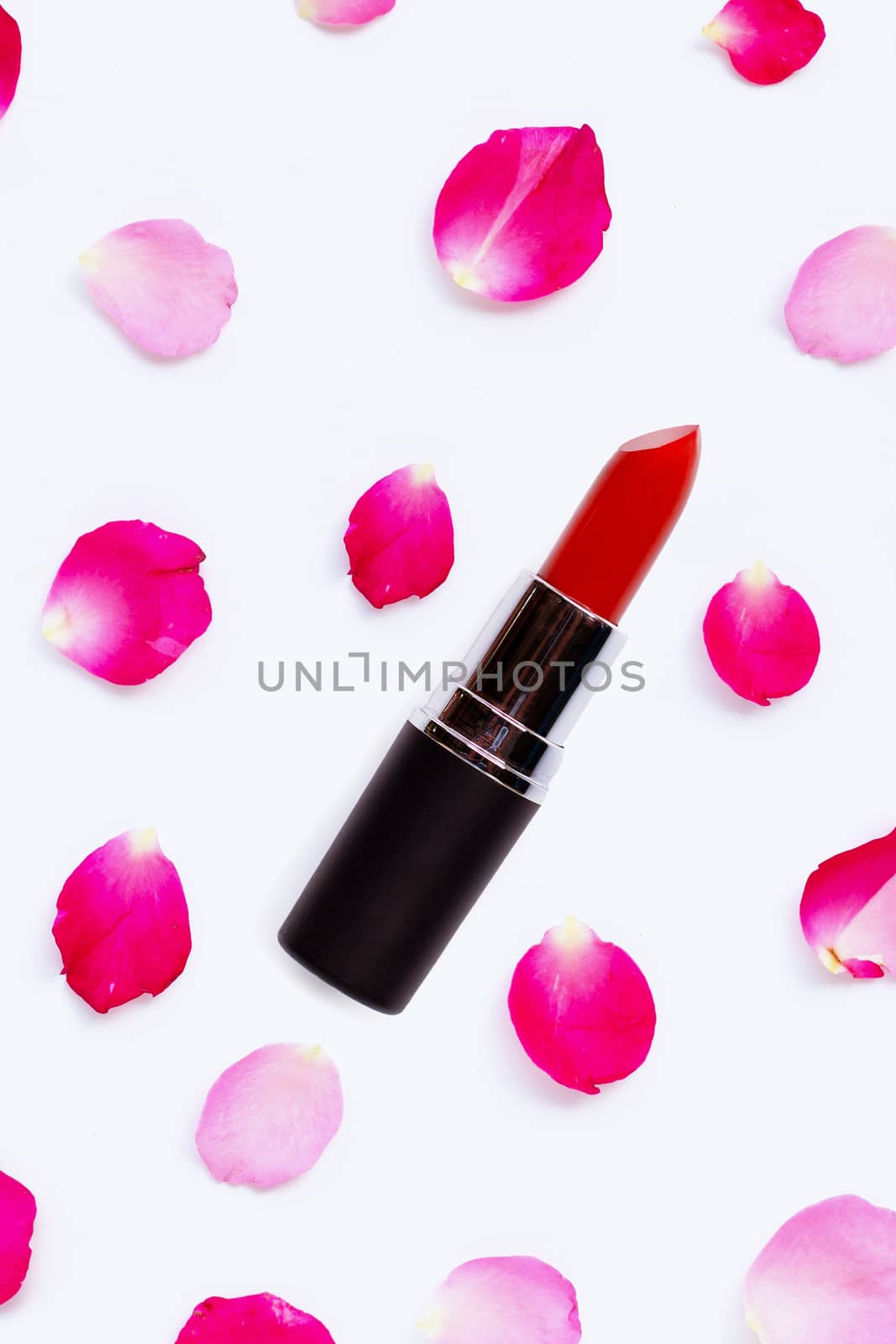 Lipstick with rose petals isolated on white background. 