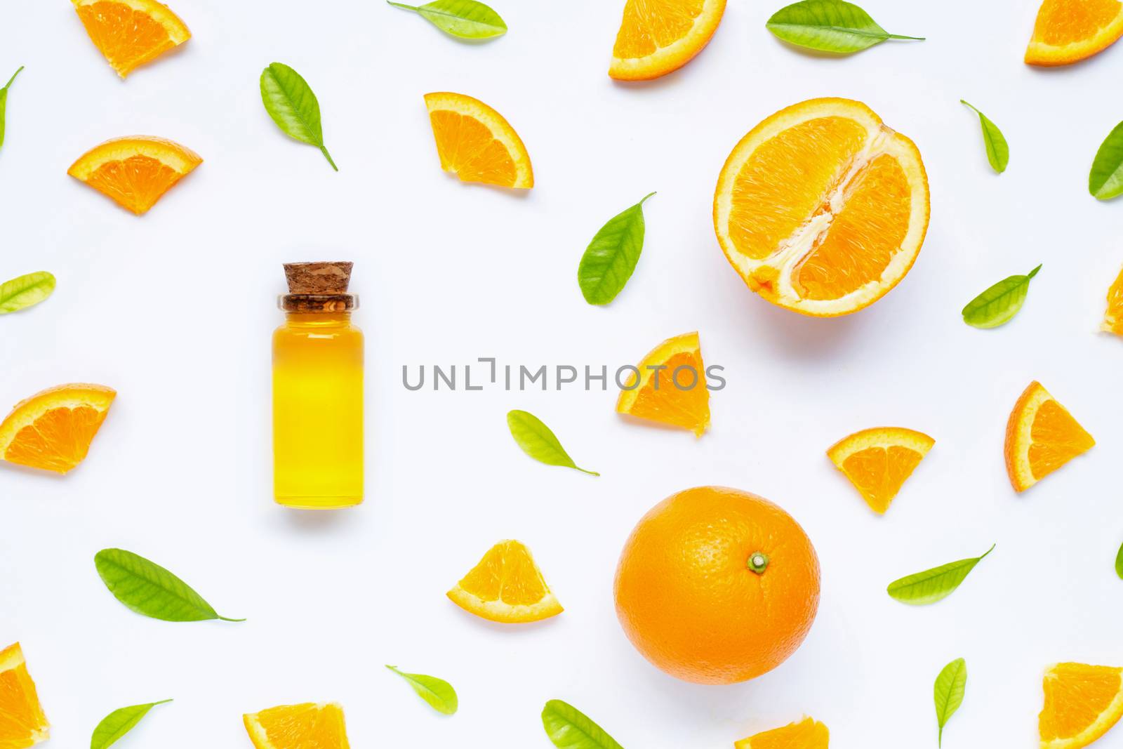 Natural citrus oil with fresh orange fruit and green leaves  on white background. High vitamin C. Top view