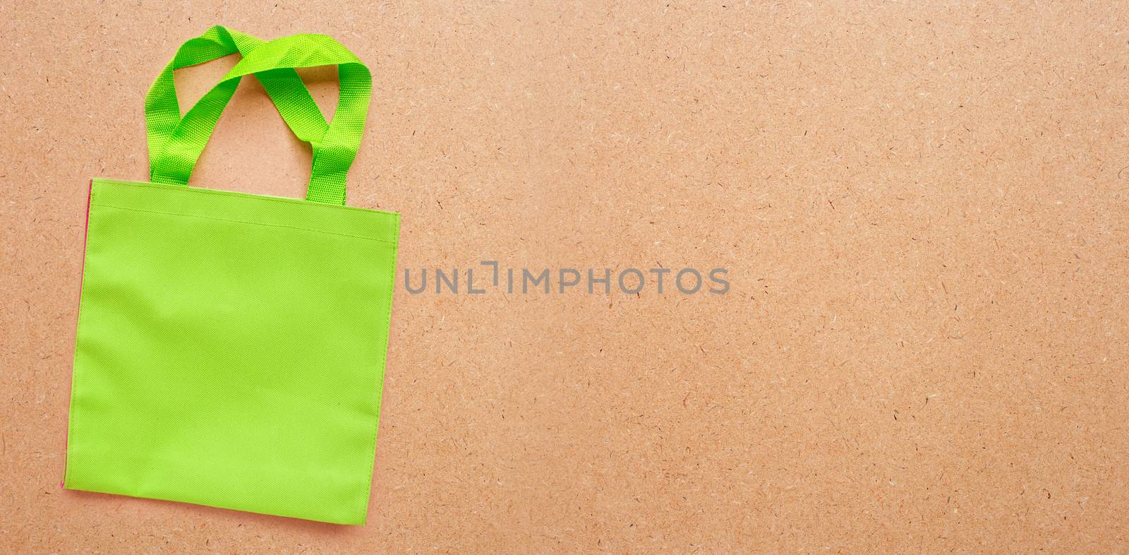 Green bag  on plywood background.  Copy space