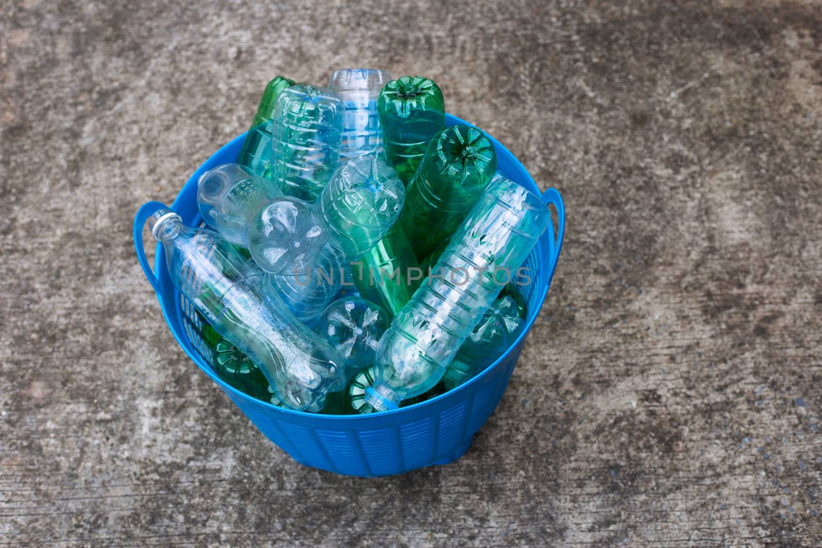 Plastic bottles in blue waste basket.