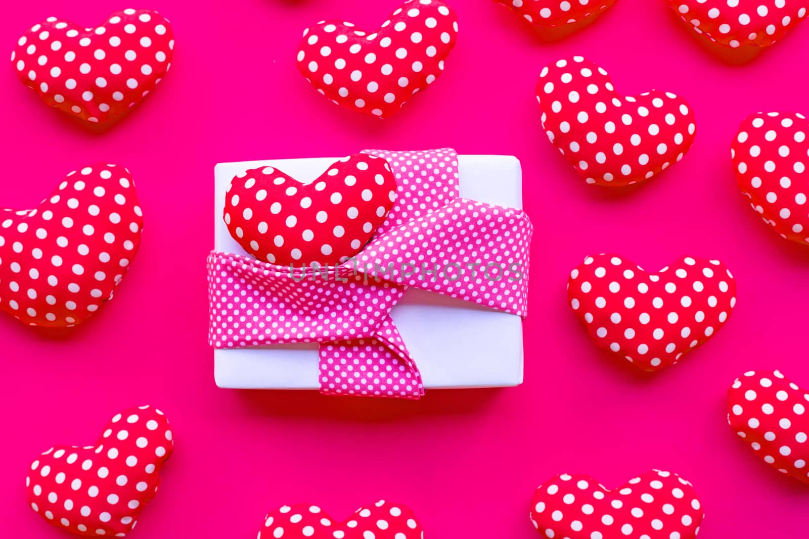 Gift box with Valentine's hearts on red background. Top view 