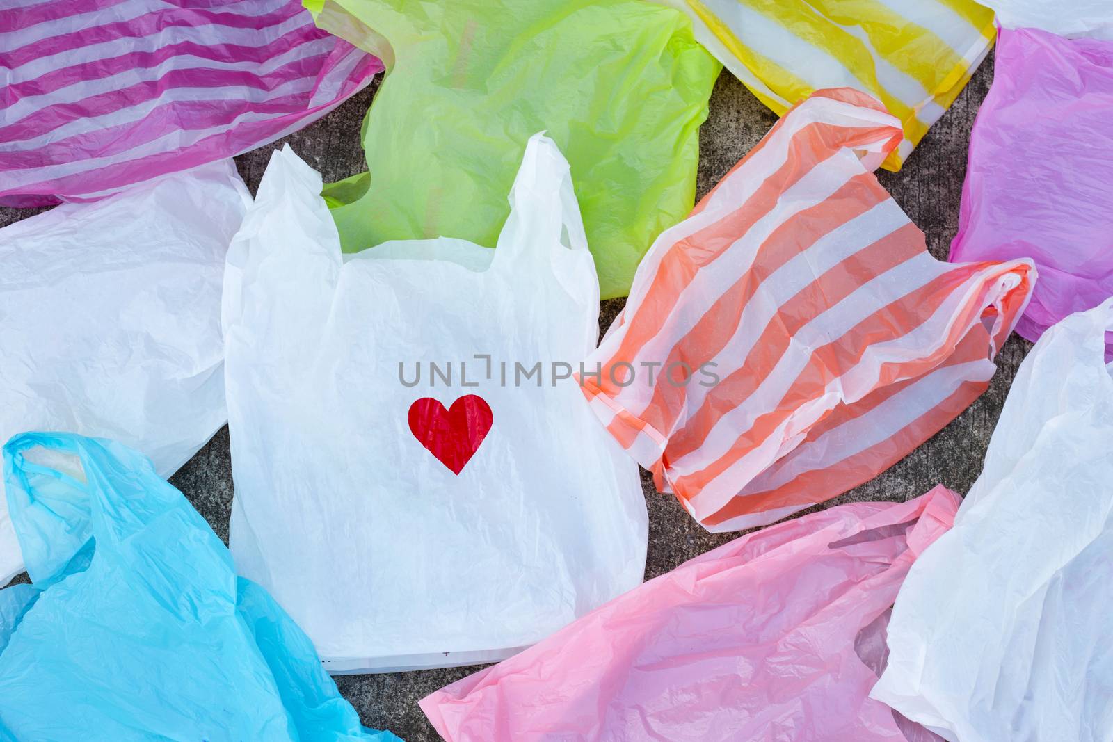 Colorful plastic bags on cement floor background