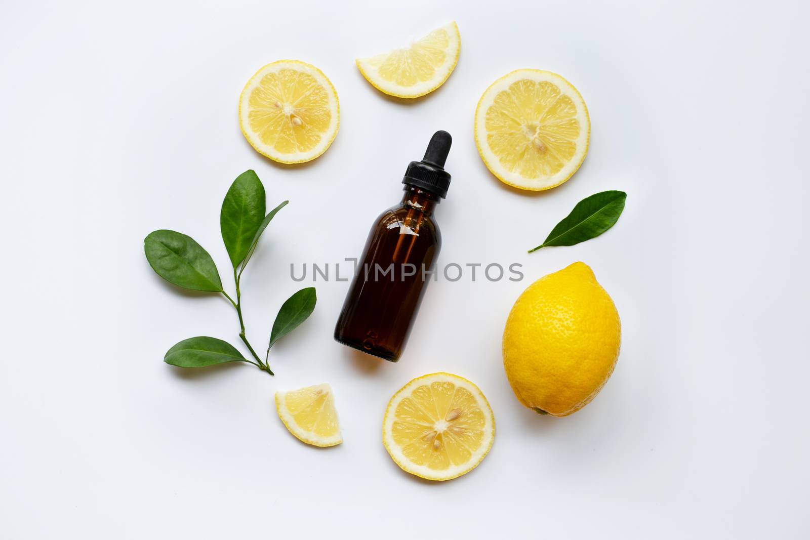 Fresh lemon with lemon essential oil on a white background.