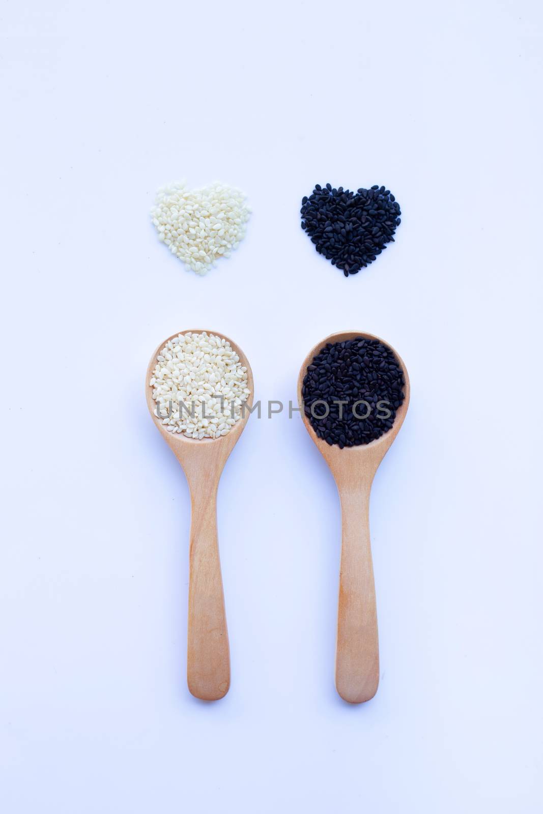 Black and white sesame seeds on wooden spoon, white background. by Bowonpat