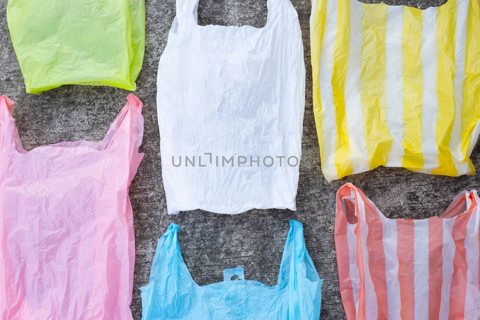 Colorful plastic bags on cement floor background.