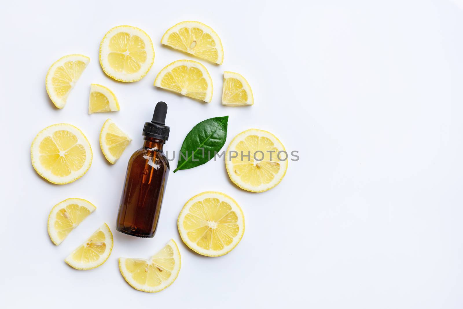 Fresh lemon with lemon essential oil on a white background.